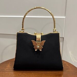Elegant Black and Gold Handbag with Butterfly Accent